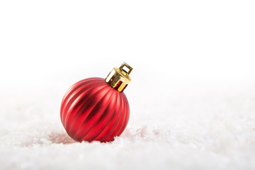 Red christmas ball on snow over white background