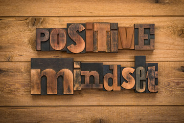 positive mindset, phrase written with vintage letterpress printing blocks on rustic wood background - obrazy, fototapety, plakaty