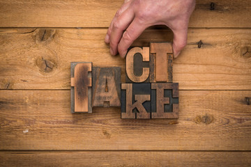 Facts and fake concept. Hand replacing letters to unveil the truth