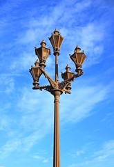 Fototapeta na wymiar Old beautiful lantern on blue sky background. An antique street lamp in the old city. Close up view.