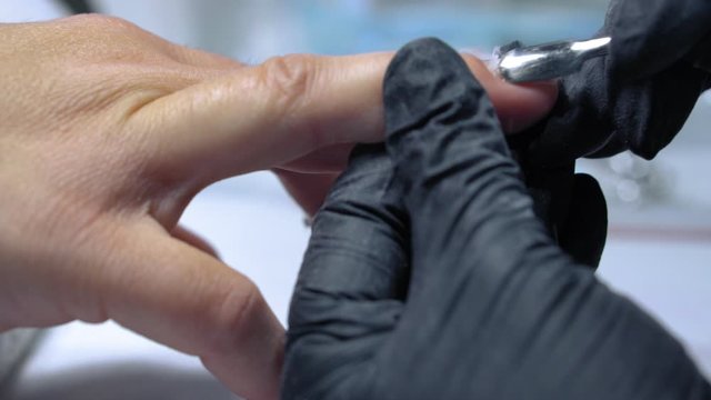 The procedure for removing gel polish from nails  in progress. Gel nail polish remover foils on woman's hands.