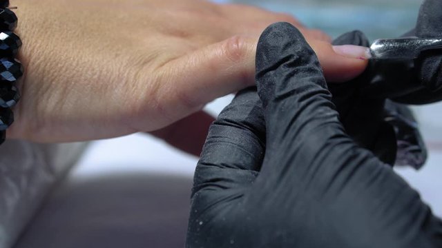 The procedure for removing gel polish from nails  in progress. Gel nail polish remover foils on woman's hands.