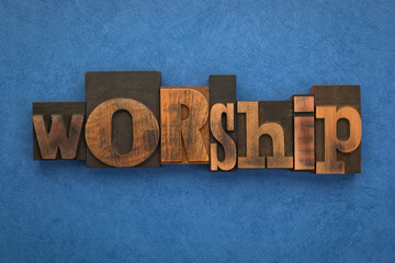 Worship, word written with vintage letterpress printing blocks on textured blue background