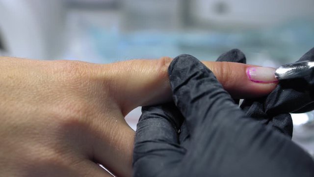 The procedure for removing gel polish from nails  in progress. Gel nail polish remover foils on woman's hands.