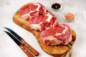 Fresh raw rib eye steak on a light background. Organic food. Top view.