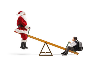Santa Claus playing on a seesaw with a schoolboy