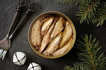 Baltic sprats in an iron can on a black background.