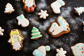 Fototapeta na wymiar Christmas gift gingerbread on dark background. Christmas gingerbread cookies with icing sugar. Top view