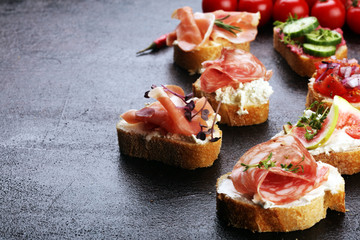 Assorted bruschetta with various toppings. Appetizing bruschetta or brie crostini. Variety of small sandwiches. Mix bruschetta on table
