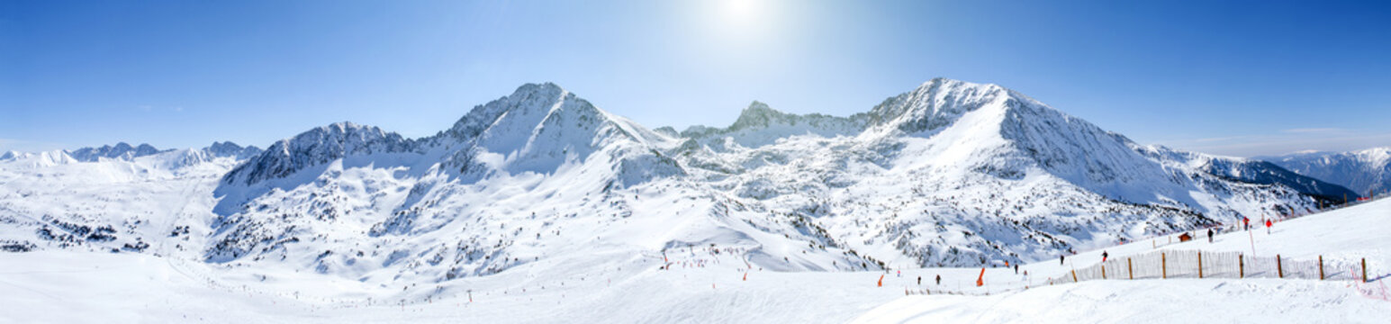winter high mountain chains landscape on a Sunny day. long ski slopes, lifts, skiers, snowboarders and snow-capped mountains in the ski resort