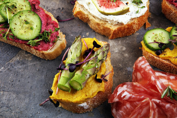 Assorted bruschetta with various toppings. Appetizing bruschetta or brie crostini. Variety of small sandwiches. Mix bruschetta on table