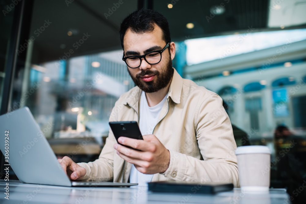Poster asian businessman holding smartphone checking notifications about incoming mail while working remote