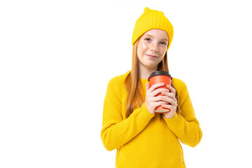 Portrait of a girl with a yellow hat with glass of drink on a white studio background
