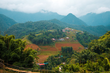 Houses and homes on top of Rice terraces outside the beautiful village of Sapa in Northern Vietnam, surrounded by mountains