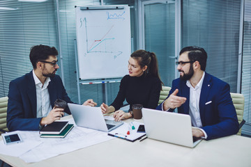 Confident male and female traders spending time for cooperation together in modern company office, caucasian business people in formal wear discussing ideas for productive conference in workspace