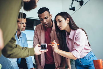 Millennial hipster guys checking notification for cellphone application connected to 4f wireless for browsing internet indoors, male and female bloggers using smartphone device for installing app