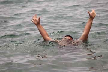 Gestures of a drowning man calling for help at sea. Horizontal, cropped picture, close-up. Water safety concept.