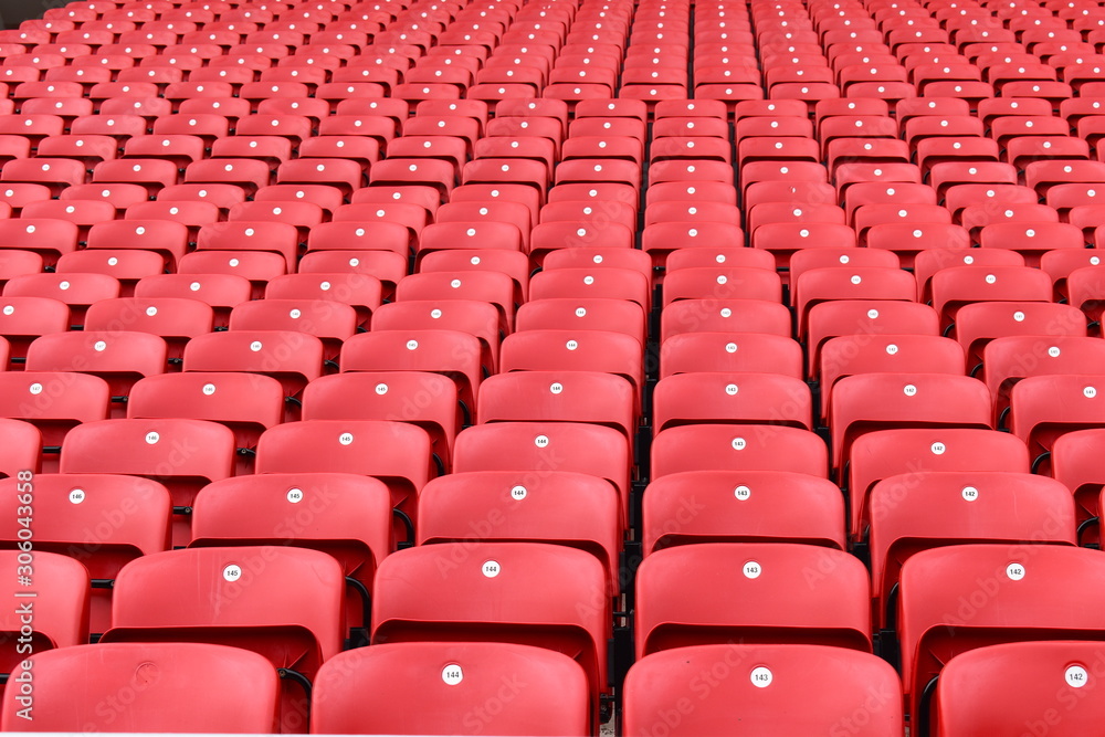 Wall mural Red plastic seats in a stadium. Liverpool FC fan zones open four hours before kick-off on a match day and are great place for supporters to soak up the atmosphere of Anfield. Liverpool, UK