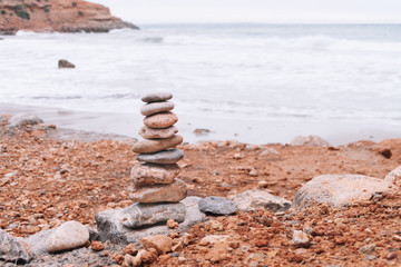 Fototapeta na wymiar Stacked stones in front of the sea. Mediterranean sea. Ibiza Sa Caleta