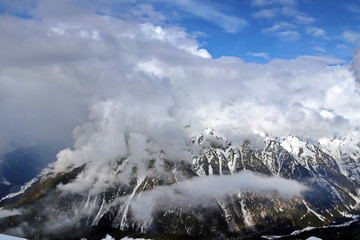 Snowy Mountains peaks in the clouds blue sky Caucasus