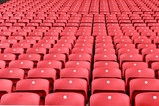 Red plastic seats in a stadium. Liverpool FC fan zones open four hours before kick-off on a match day and are great place for supporters to soak up the atmosphere of Anfield. Liverpool, UK