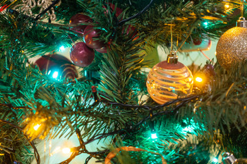 Colourful fairy lights and baubles decorate a Christmas tree.