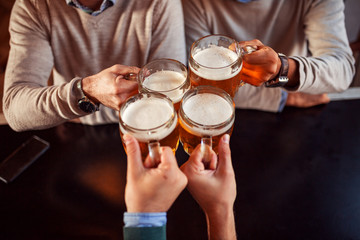 Fototapeta na wymiar Image of four friends clinking with beer