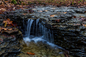 Fototapeta na wymiar McConnell Mills State park waterfalls in autumn in color hell's hollow
