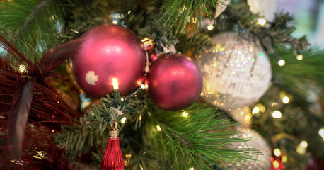Christmas decorations on xmas tree with hanging balls and ornaments and bokeh background.