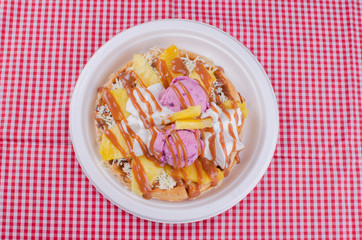 waffles with ice cream, chopped fruit and sauces