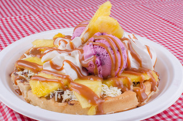 waffles with ice cream, chopped fruit and sauces