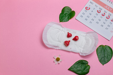 menstruation calendar with Sanitary pad and sanitary napkin, bloods, calendar and injection close-up on a pink background.