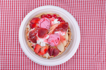 waffles with ice cream, chopped fruit and sauces