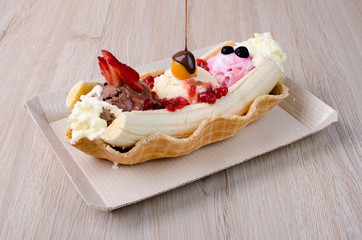 banana split with chopped fruits and sauces