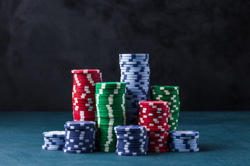 stack of poker chips on a blue table on a black background