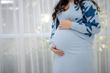 Beautiful young women in the third trimester of pregnancy Pregnant woman holding arms in her...
