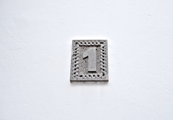 Number 1, one, stone relief on white background.