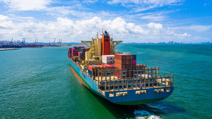 Container ship at industrial port in import export business logistic and transportation of international by container ship in the open sea.