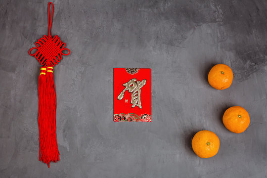 Chinese New Year decoration with tangerines and red envelopes on gray concrete background. Happy Chinese new year 2020 festival. Text appear in image: Congratulate
