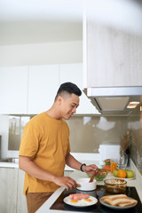 Fototapeta na wymiar Happy Asian man preparing food in the kitchen at home.
