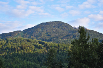Fototapeta na wymiar Whistler mountains with Whistler Mountain peak on the right side on a summer morning