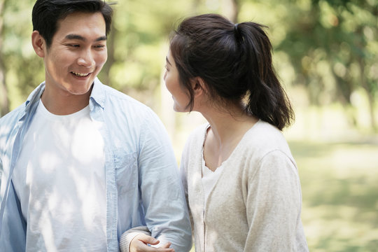 young asian couple walking in park