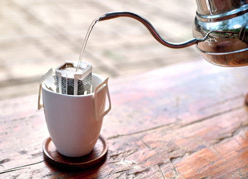 Hot Water Pour Over Drip Coffee Using Paper Type Filter On Wooden Background.