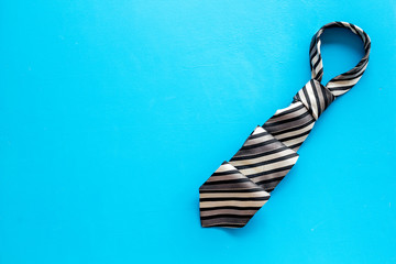Father's day concept. Men's tie on blue background top-down copy space