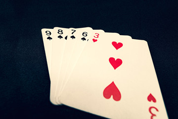 Straight flush of spades on black background