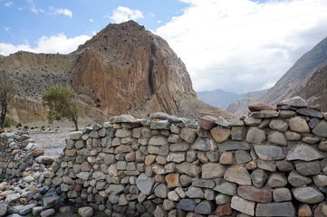 The traditional stone protection from the winds against the backdrop of the Himalayan mountain takes place in the upper reaches of the Mustang. Hike in the closed area of the upper Mustang. Nepal.
