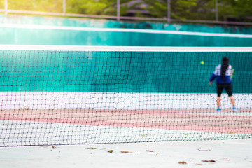 Tennis court that focuses the mesh in front and blur the person who is playing tennis.