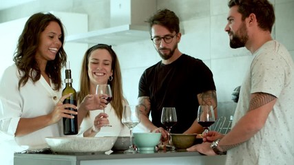Smiling woman pouring wine in glasses. Cheerful friends clinking glasses and drinking red wine. Wine tasting concept