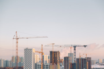  Panorama of construction with cranes in the afternoon. Construction of a modern residential complex.