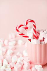 Mug with candy and marshmallow hearts on pink background. Romantic, St Valentines Day concept, greeting card. Seasonal winter february holiday, woman, mother day